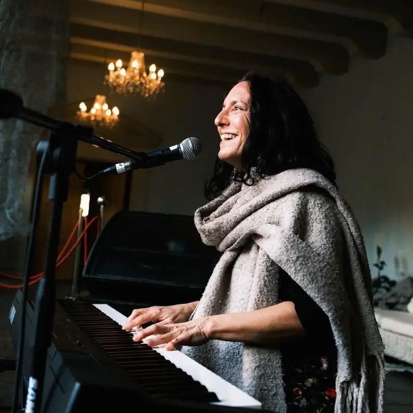 Bush Diva singing and playing keyboard, smiling