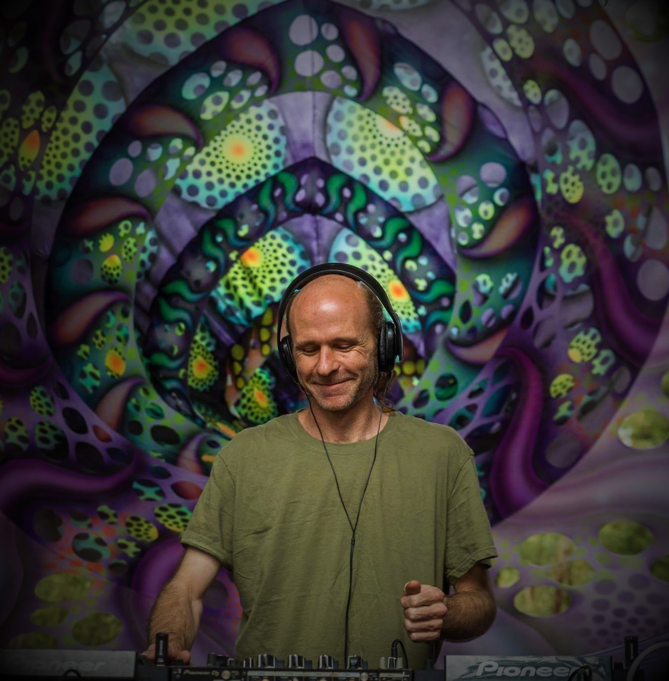 Thomas performing in front of psychedelic stage art