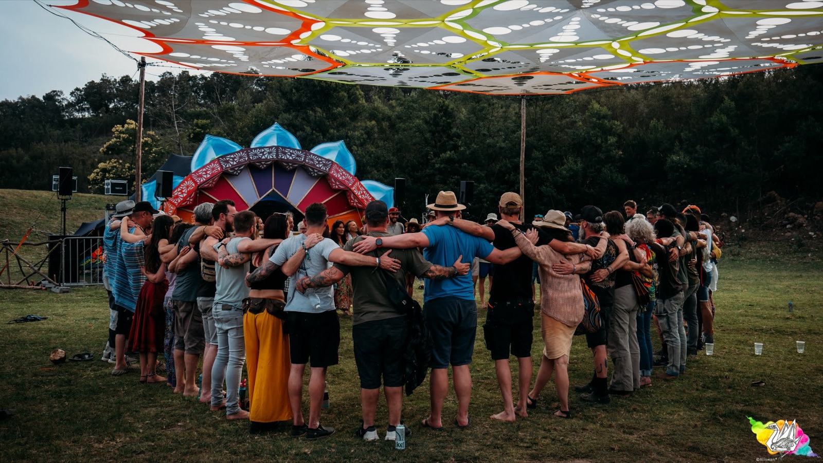 A circle of people with linked arms at Earthdance Cape Town 2025