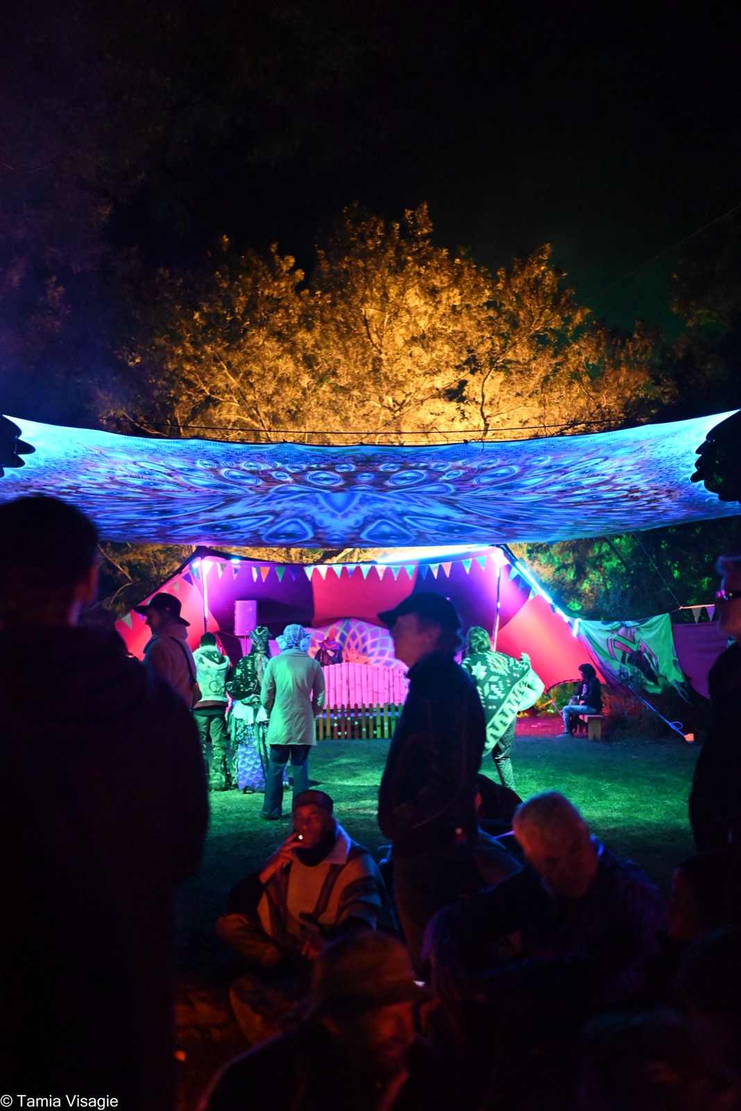 A quiet night gathering beneath a decorated canopy