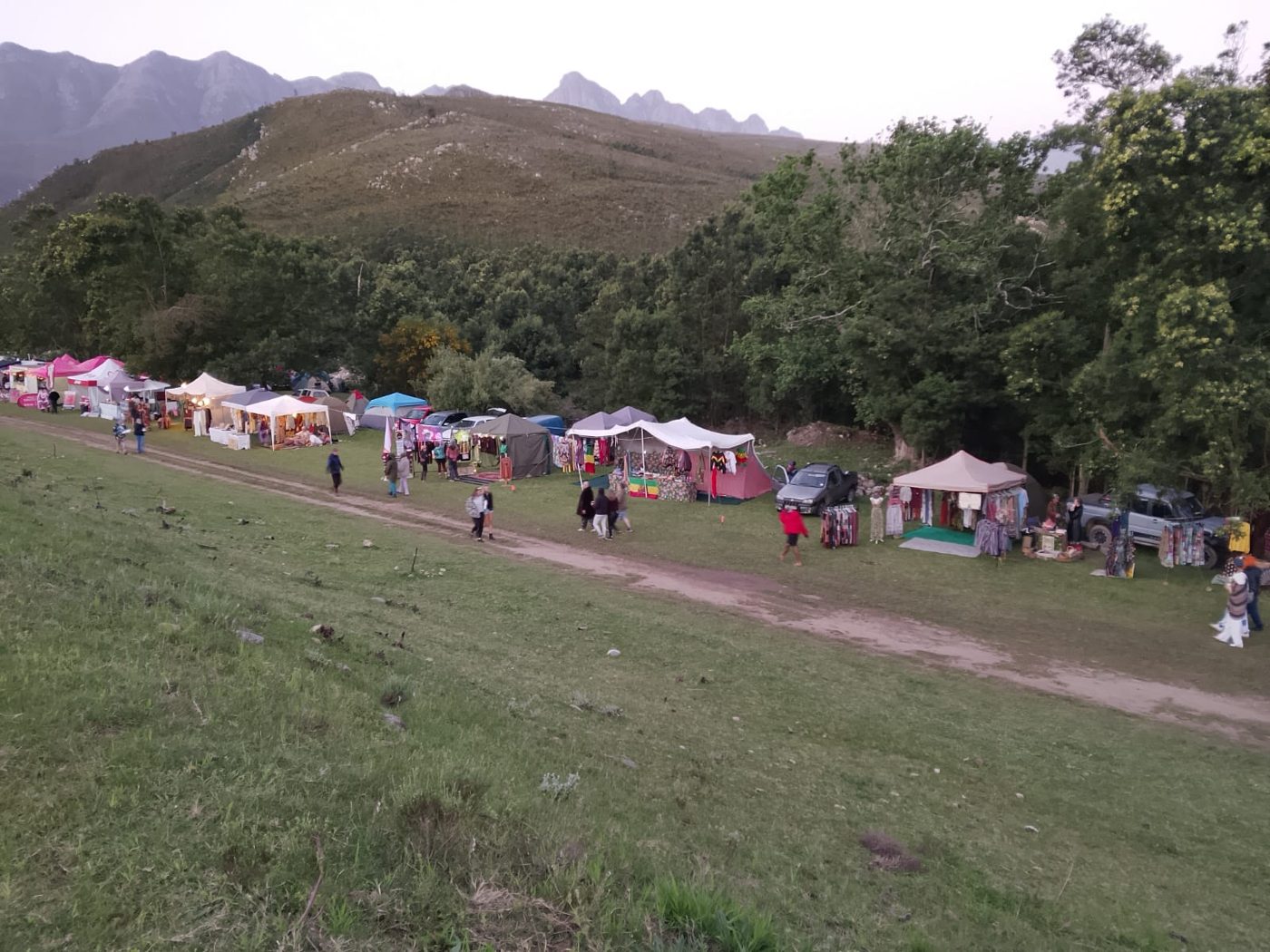 The row of vendor stalls along the track, with the mountains behind