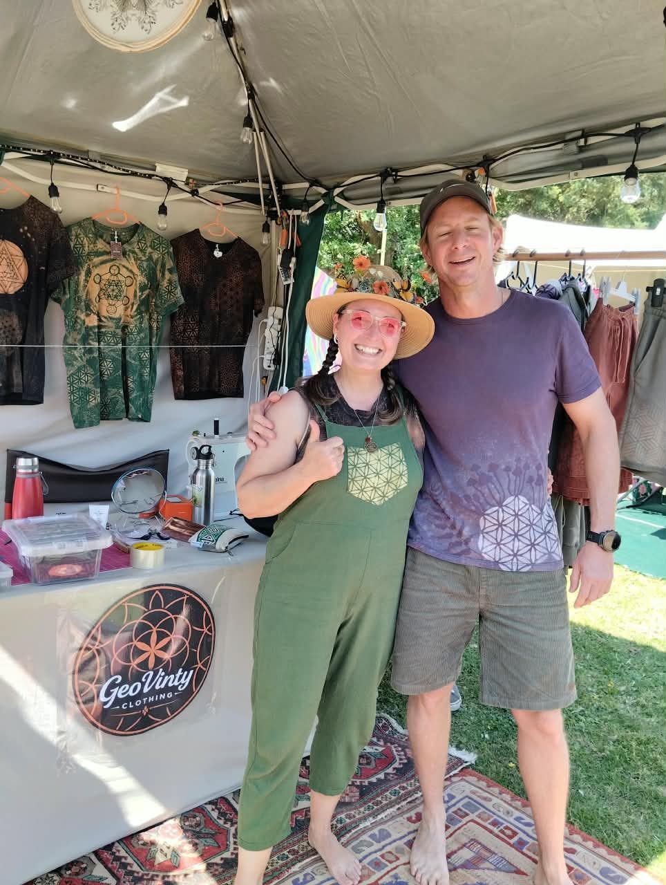 Two GeoVinty vendors smiling at the stall counter, the logo on the table