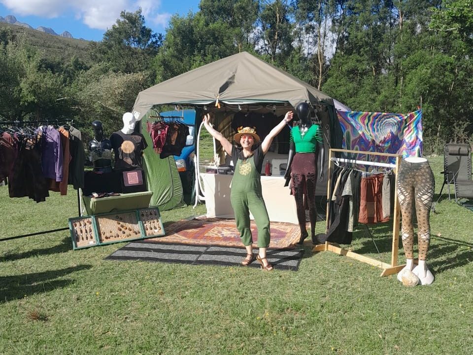 The GeoVinty tent on the grass, with clothing rails either side and the vendor with arms raised