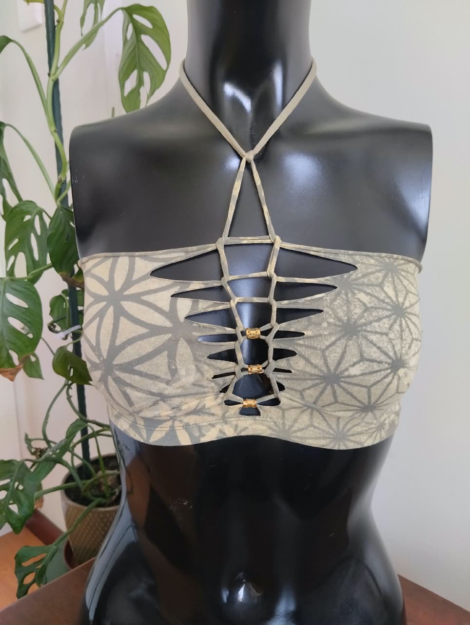 Sage-green halter top with a laser-cut flower-of-life lattice at the chest