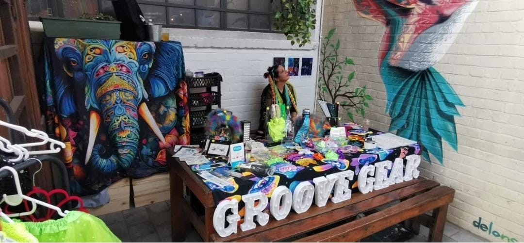 The Groove Gear stall, with light-up letters spelling Groove Gear and a colourful table of festival accessories
