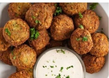 A bowl of golden chickpea falafel with tahini dip