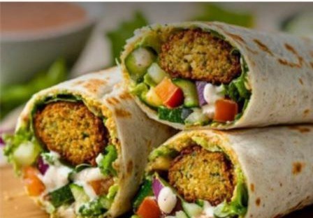 Munchies falafel wrap, sliced open to show fresh vegetables and tahini sauce